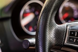 close up image of a car steering wheel with function buttons